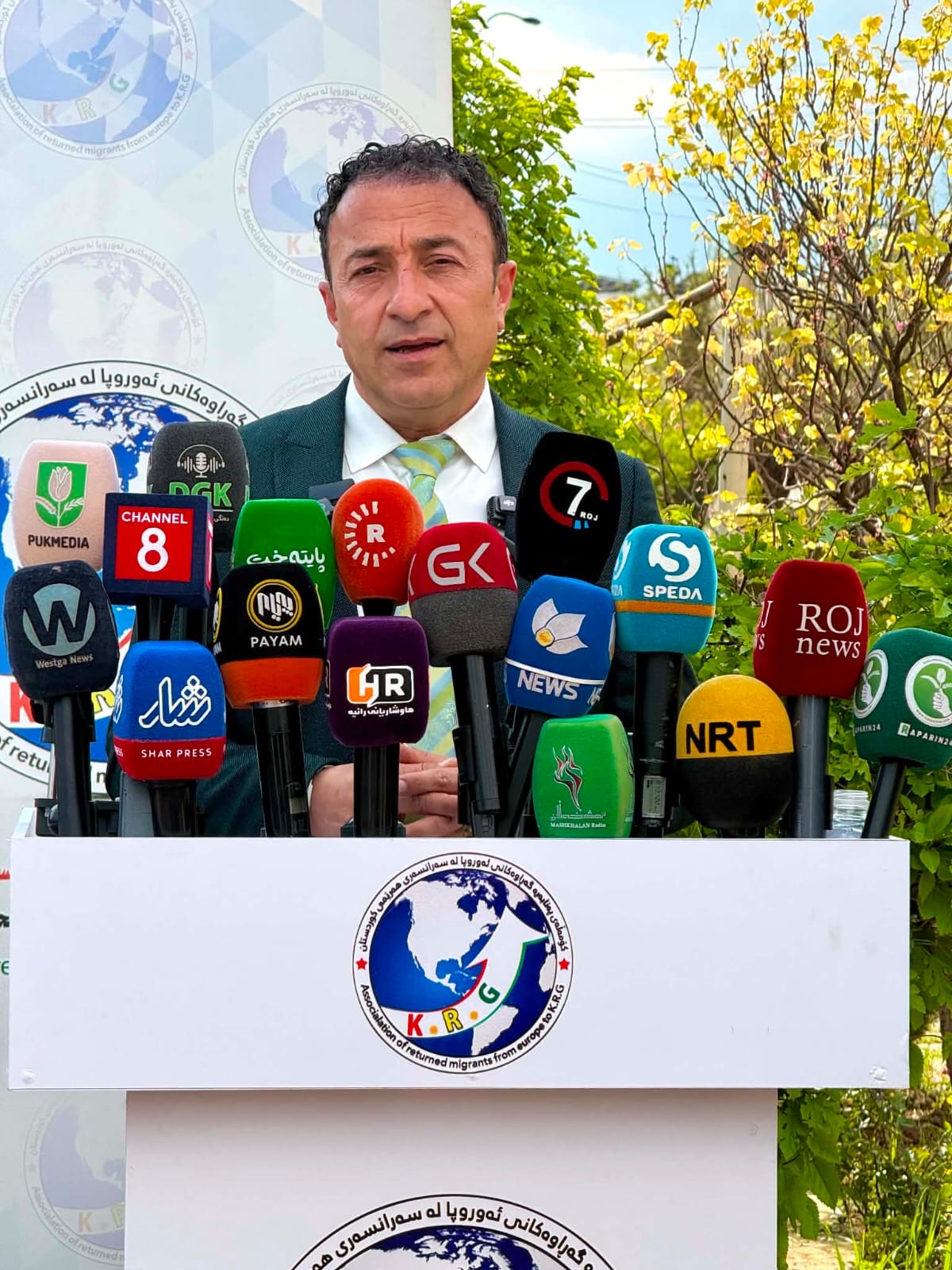 President Abubakr Ali Aziz delivering an official statement at an Association press podium attended by national and regional media.