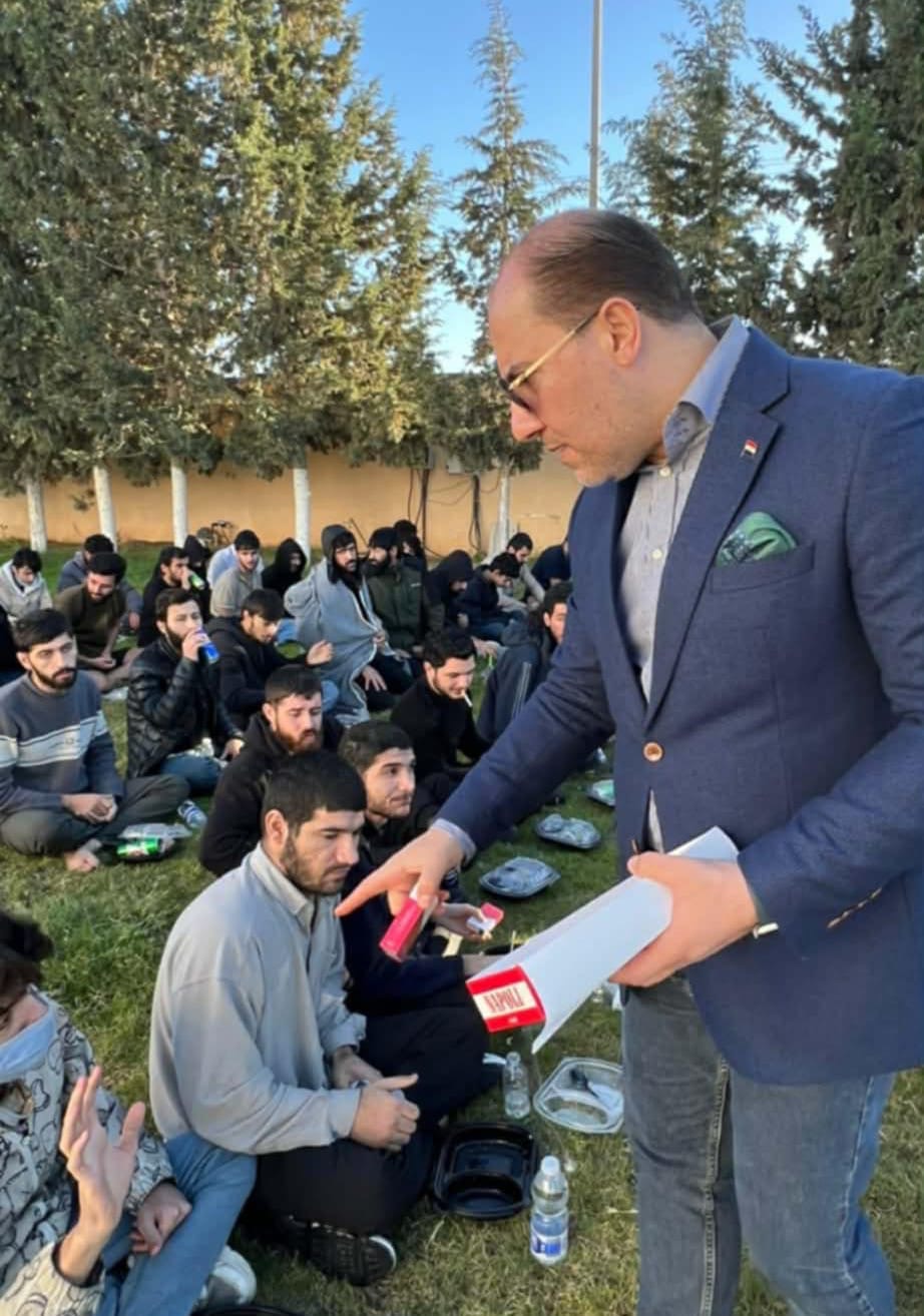 President Abubakr Ali Aziz distributing essential supplies to returned migrants on arrival.