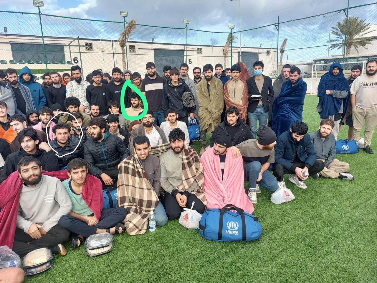 Group of Kurdish returnees at a reception centre with UNHCR relief items following repatriation.
